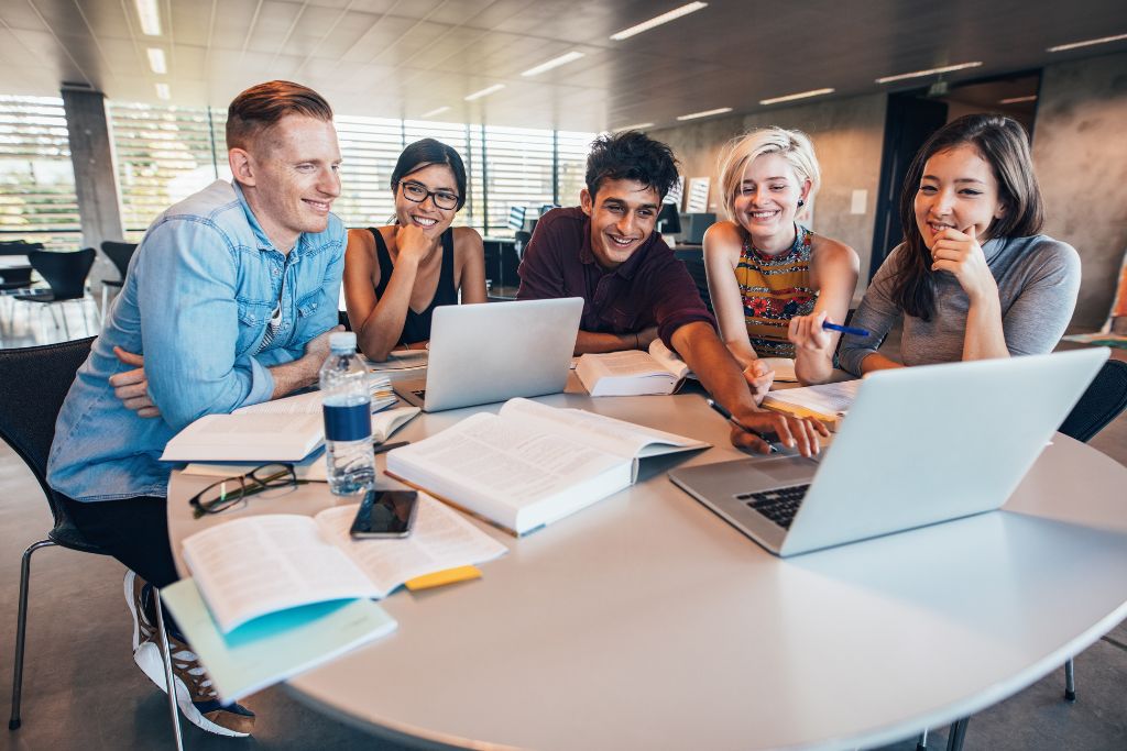 Young parents gather around an office table while on a Zoom call.