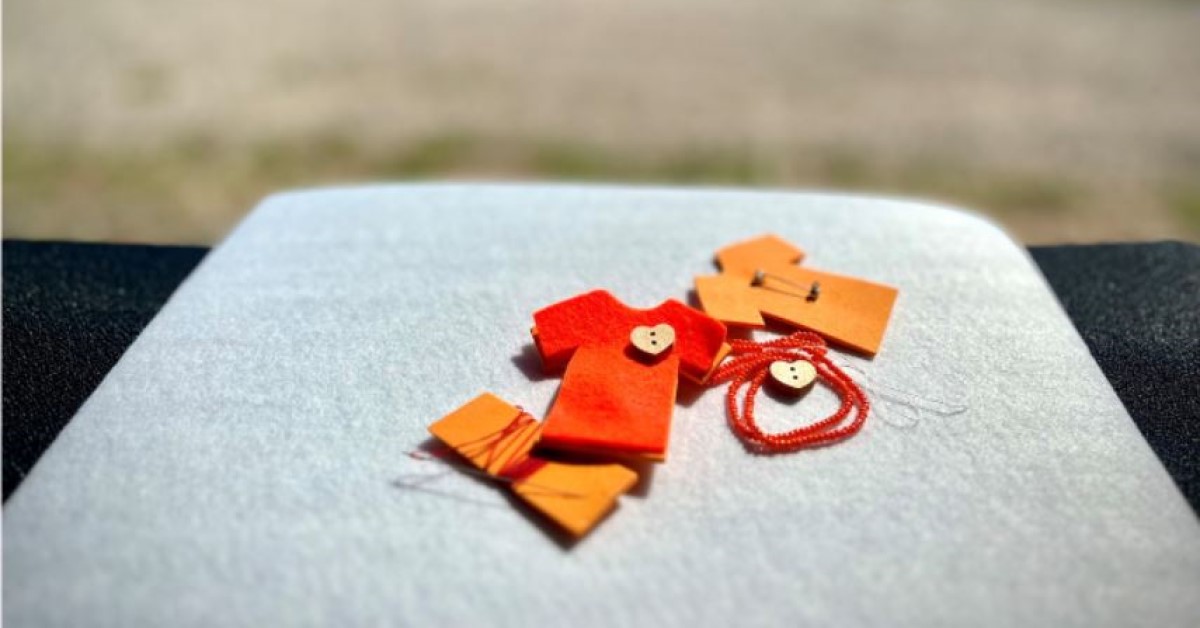 Materials for a small orange shirt pin with a button heart.