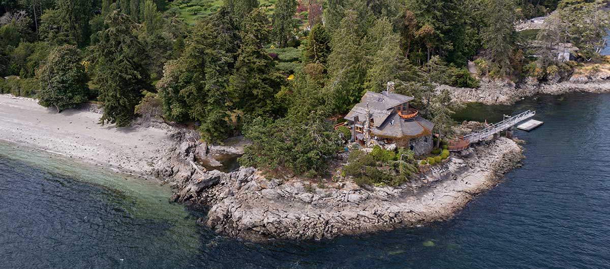 Ariel photo of a forested property and large stone building on the coast of Salt Spring Island, known now as the Bloom Castle