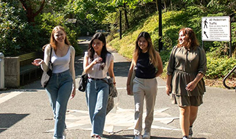 Four undergrad students stroll through campus at Royal Roads University.