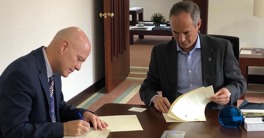 CESA Rector Henry Sicard and RRU President Philip Steenkamp sign the agreement.