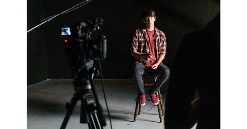 Student-sitting-in-front-of-video-camera-and-screen