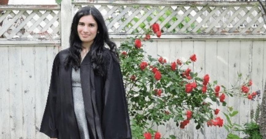 Serena Bains stands outdoors in graduation robe