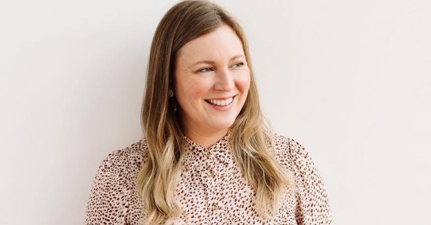 Smiling woman looks to the right of camera against a plain white background