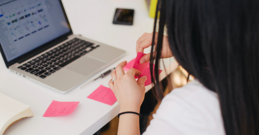 women with sticky notes in front of laptop