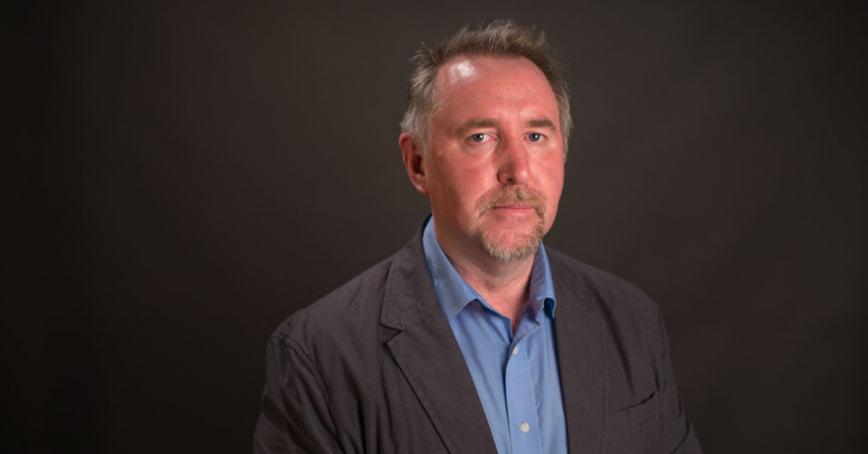 Head shot of Ken Christie with a dark background