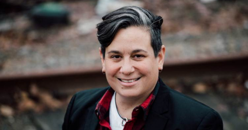 Head shot of RRU researcher Michelle Hamilton-Page standing outside with stairs in the background