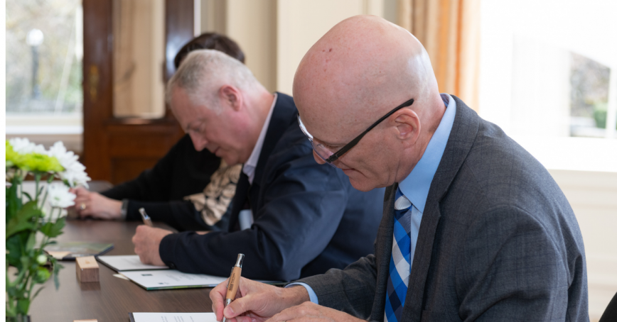 President Steenkamp signing an MOU at the same time as the presidents of VIU and Pearson College.