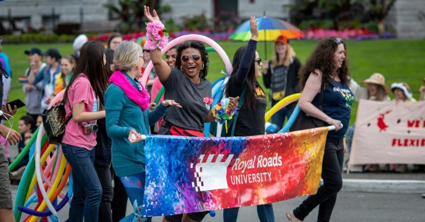 RRU Proud walk in the Pride parade behind an RRU banner.