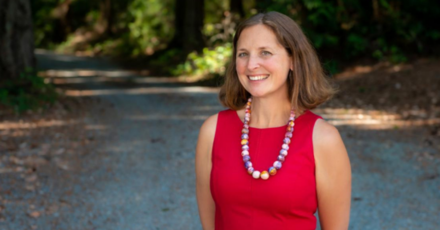 Cheryl Heykoop stands outside on a sunny path.