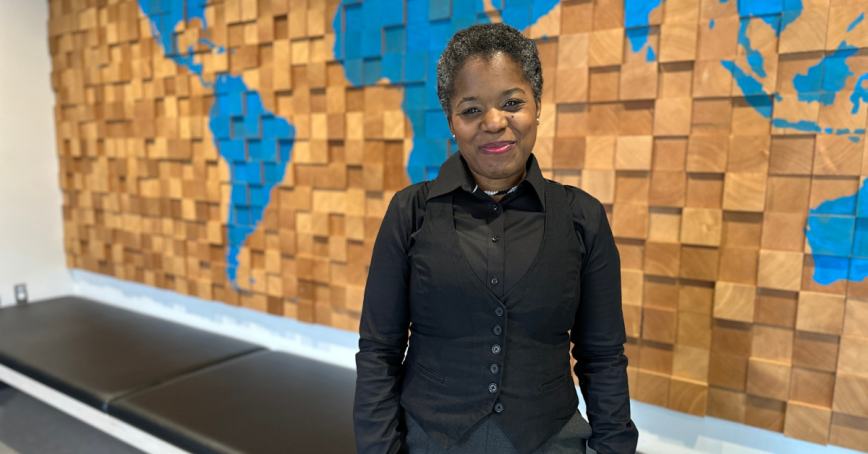 Picture of Lisa Wallace in front of a map of the world.