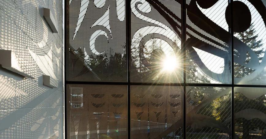 A beam of sunlight shining through a decorative wall of the Dogwood building at Royal Roads University.