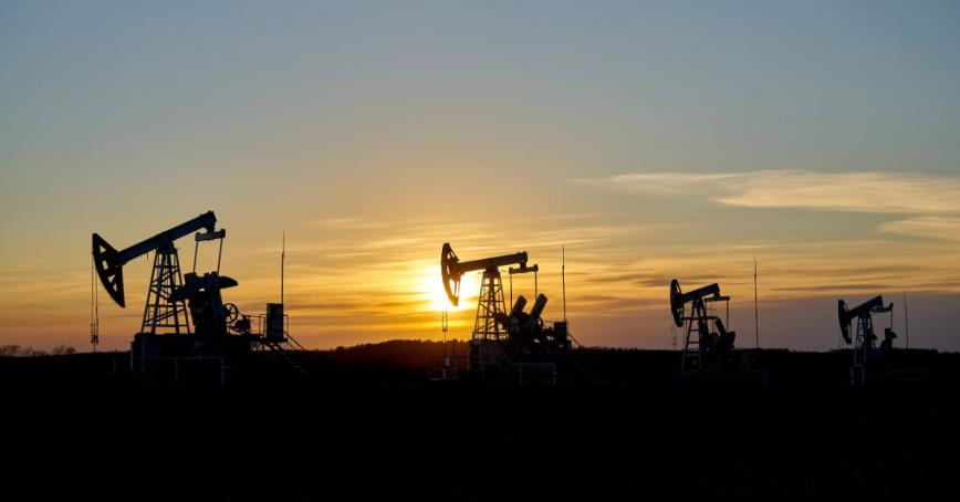 A picture of an oil drilling site at sunset