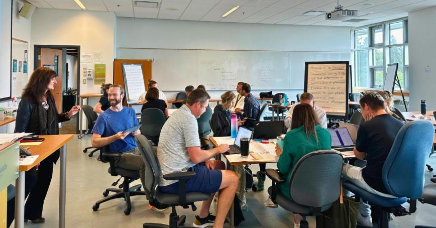 A class of MBA students work at their desks