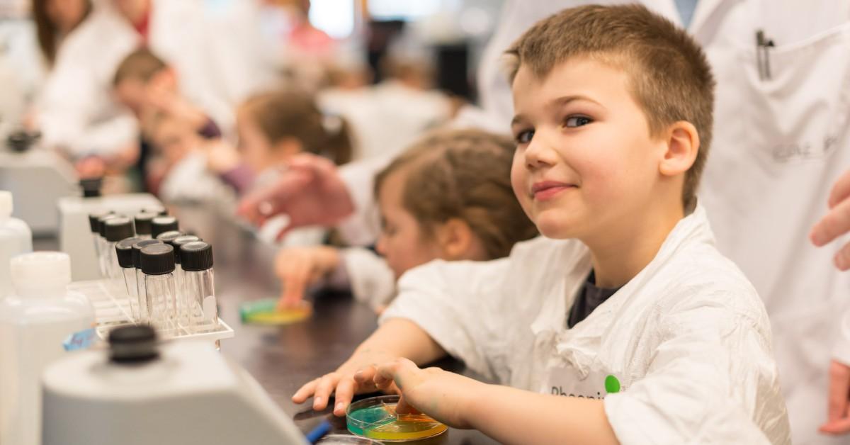 Kids sitting in a row learning in a science lab 