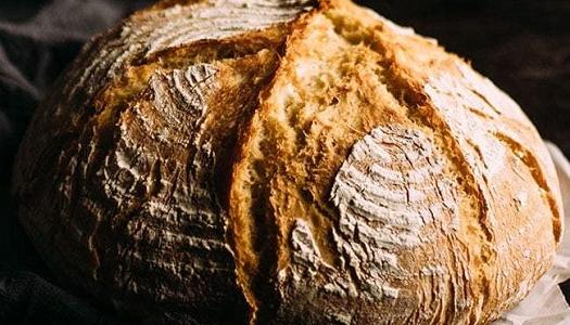 Round-loaf-of-floured-and-scored-bread