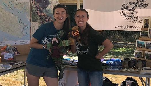 Two-educators-smiling-in-Galiano-Conservancy-booth