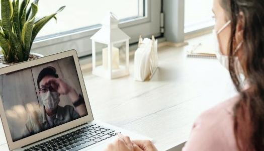 Two people video conferencing, one a patient, one a doctor.