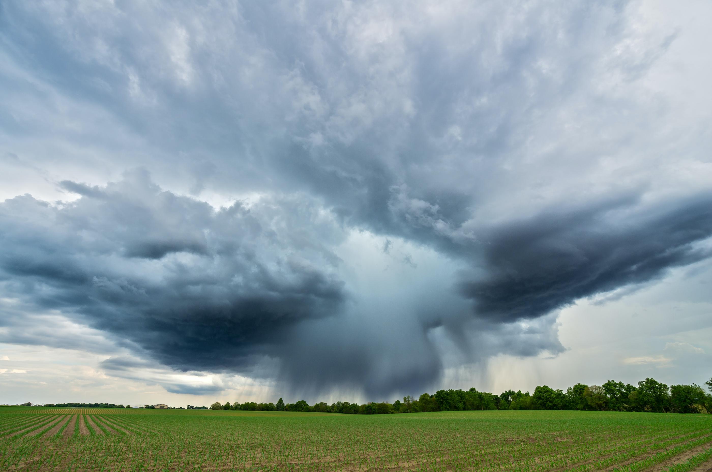 Big clouds overlooking a green field