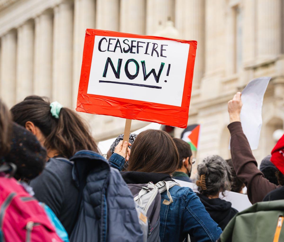 a group of people holding signs in front of a building