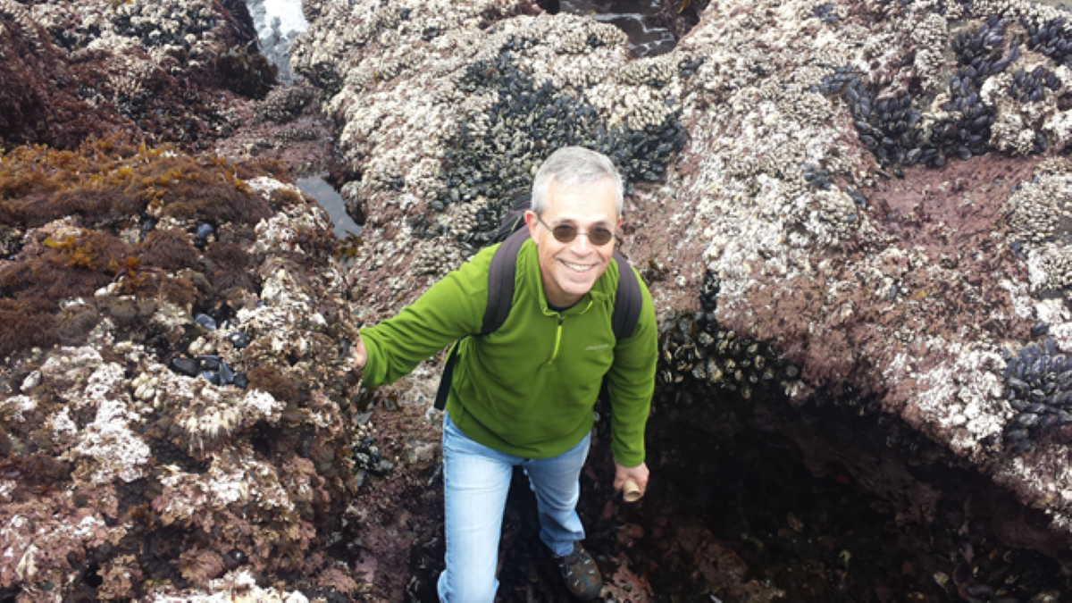 Associate Faculty Guy Nasmyth out for a hike smiling