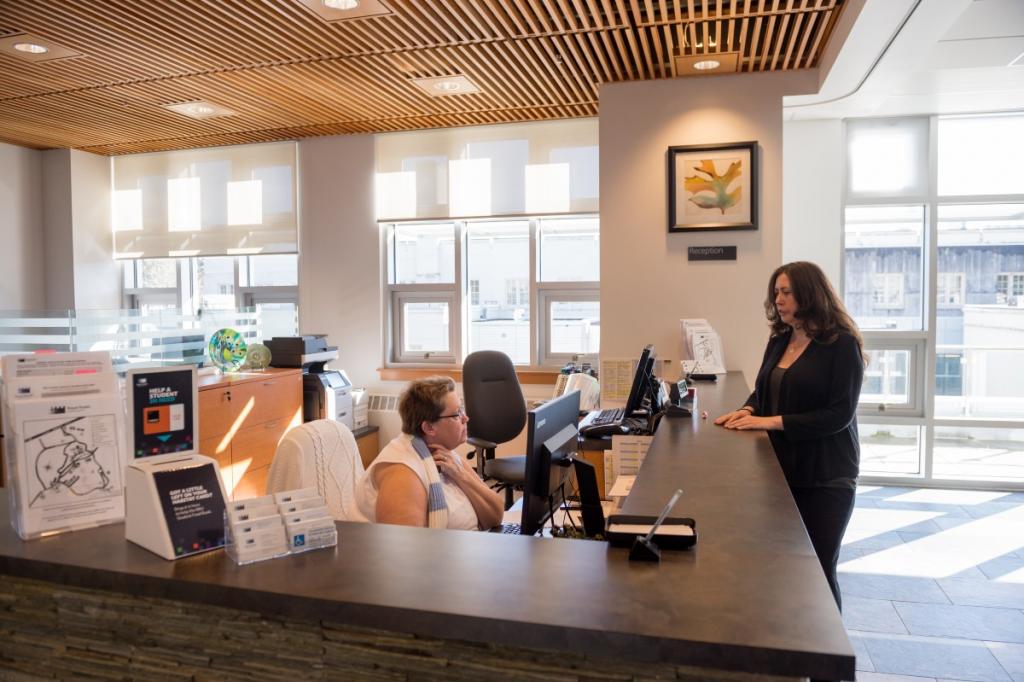 Campus-Welcome-Desk-staff-member-seated-and-student-standing-at-counter