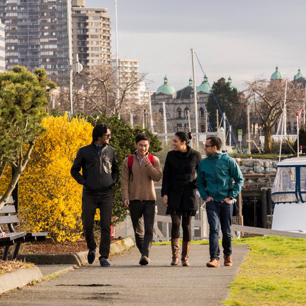 Four students walking on the Inner Harbour footpath in Victoria.