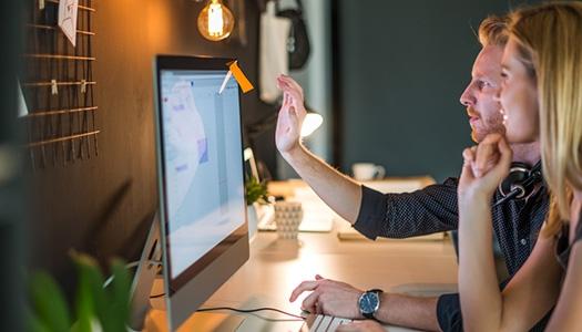 Two people looking at a computer screen.