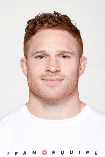 Smiling man with red hair wearing white T-shirt. Connor Braid.
