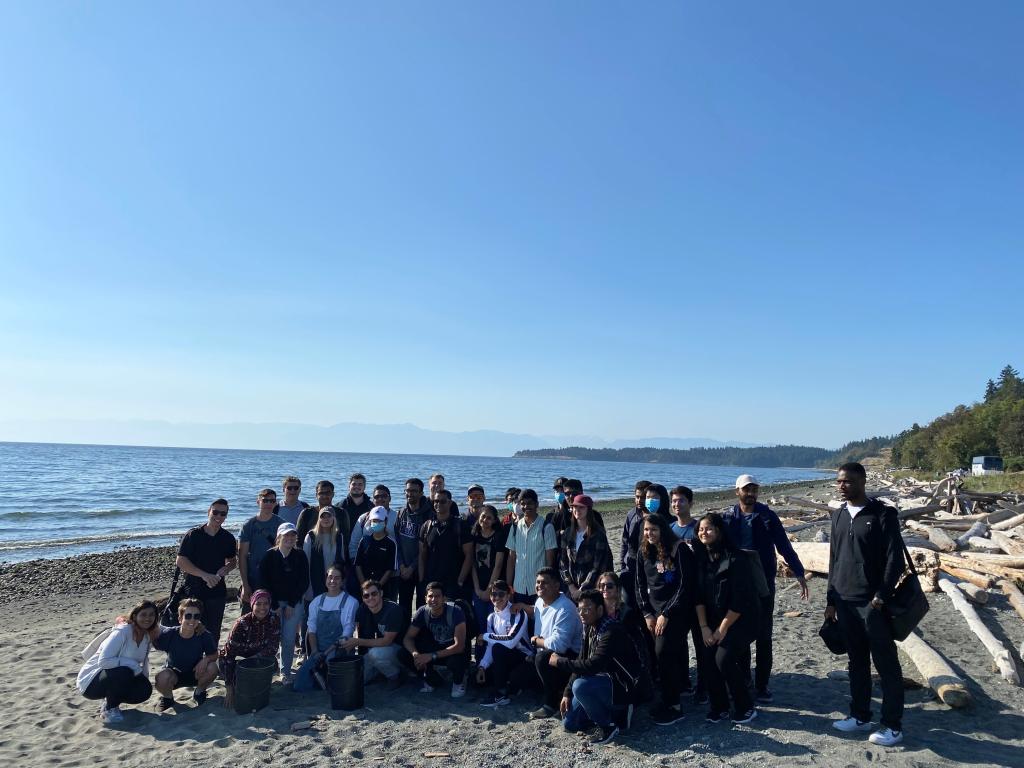 A group of BBA students stand together before the beach clean up