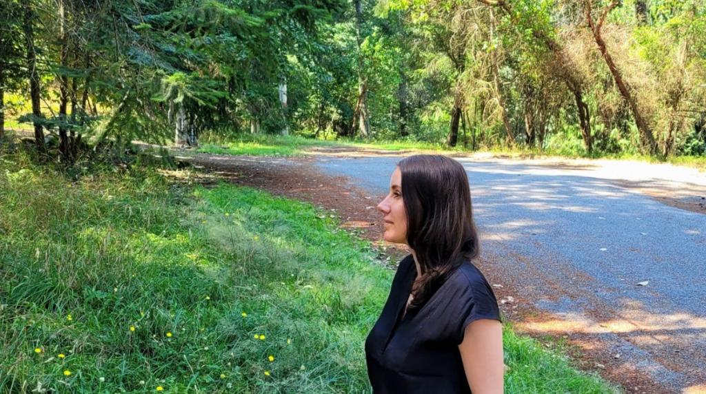 A woman stands while looking at a tree.