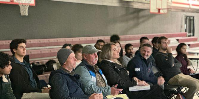 Group of people sitting down in the audience.