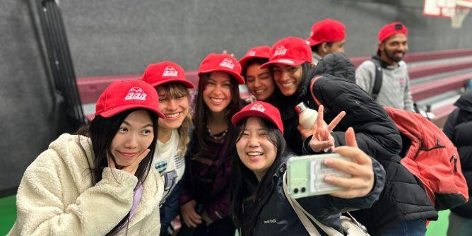 Group of people taking a selfie while wearing red hats.