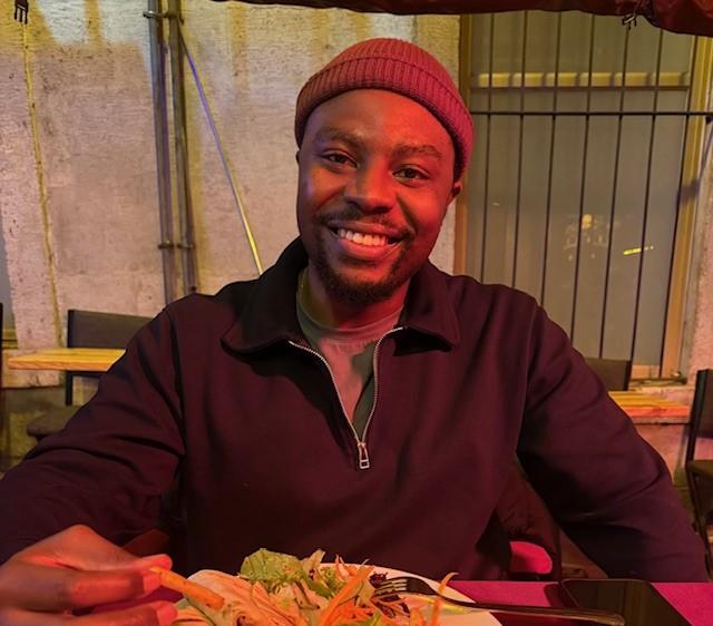 Martin Sithole smiles while eating at a restaurant