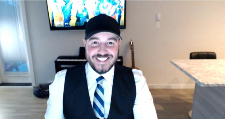 RRU student Leighton Gall sitting, smiling for a photo inside his home