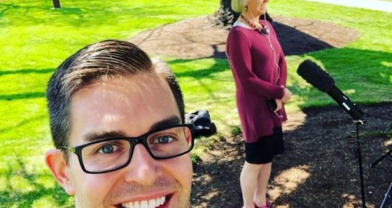 Chris Shewchuk takes a selfie of himself and Dr. Bonnie Henry standing outdoors by a microphone.