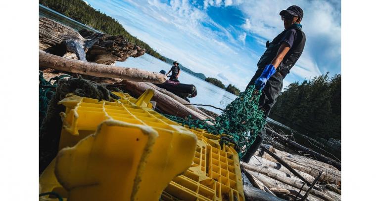 person-holding-net-next-to-plastic-crates-on-beach