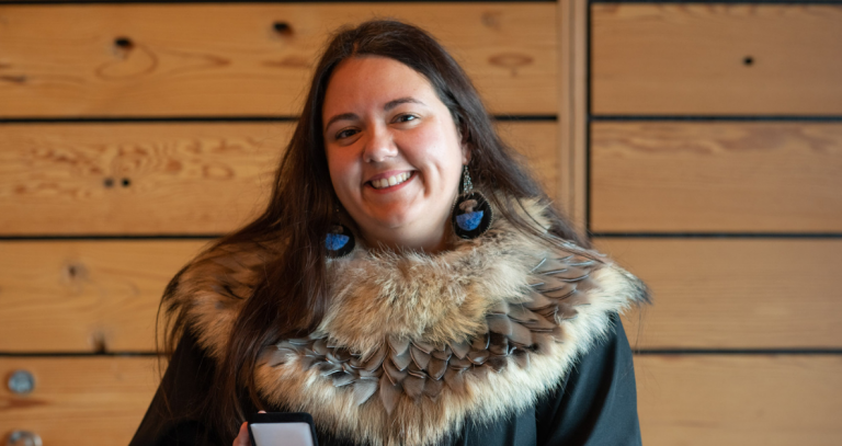 Katelynne Herchak dressed in her grad gown with fur trim, holding her Liertenant Govenor's Medal