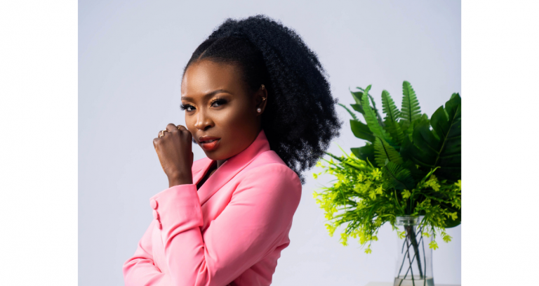 Head shot of Oluwafisayo Olayinka-Bello standing with her back to a plant filled vase