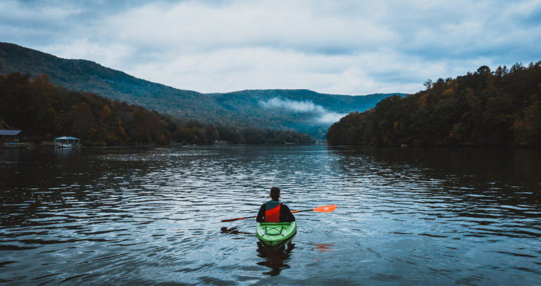 A lone kayaker takes in a mountain view.