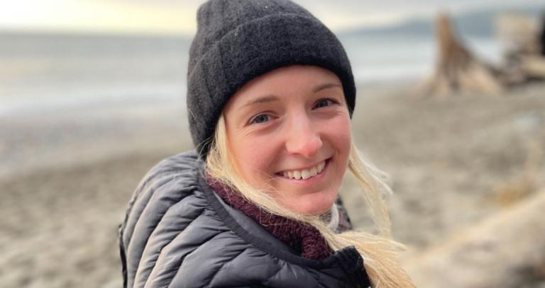 Camille Ruest smiling with a beach in the background