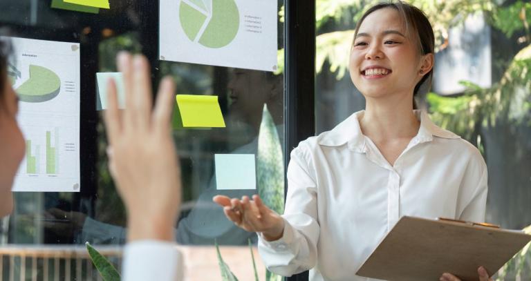 Two students in a natural office environment discussing charts