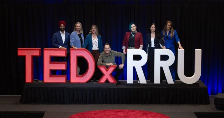 TEDxRRU 2025 speakers pose behind the TEDXRRU sign