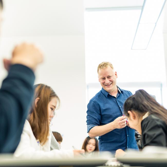 Instructor with a smile looking over students' work