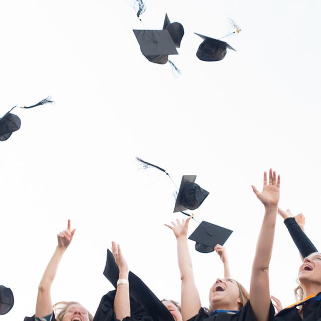 Grads-in-gowns-tossing-caps