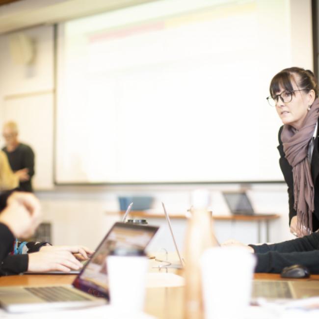 Students in classroom with large screen in background