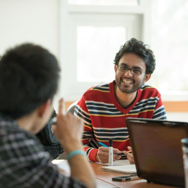 Two-students-together-at-desk-with-laptop