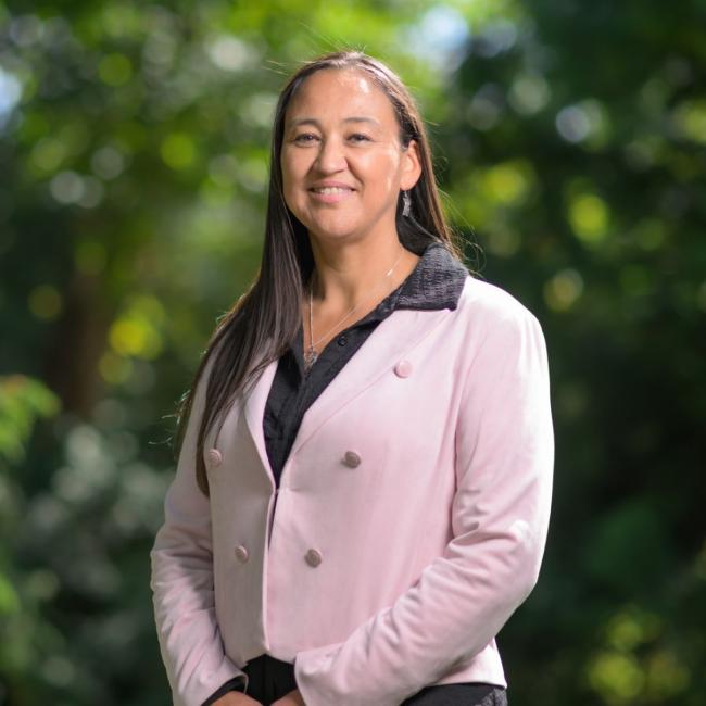 Christine Webster smiling in front of a natural background